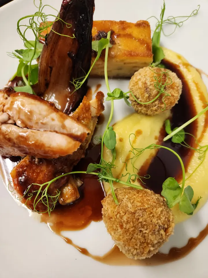 Roast meats with golden croquettes, crisp potato, pea shoots and a glossy sauce